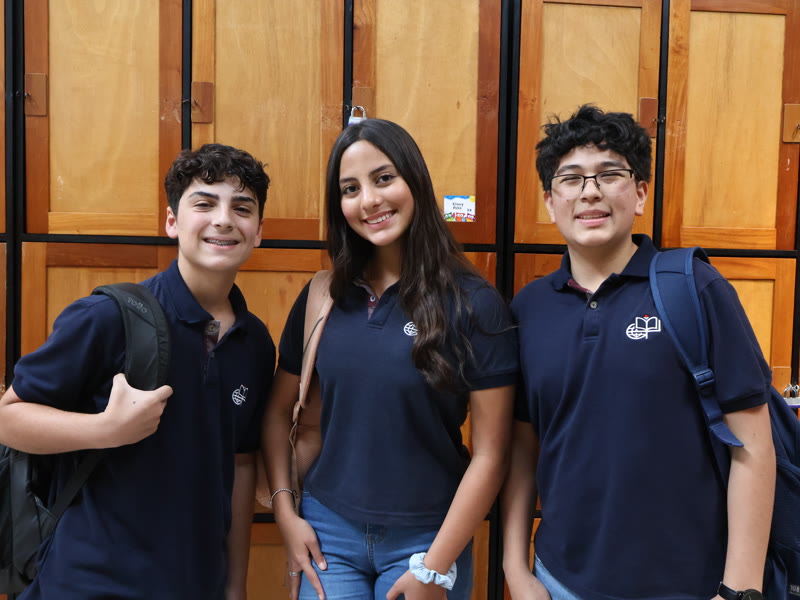 Tres estudiantes del CIG sonriendo con el uniforme institucional.