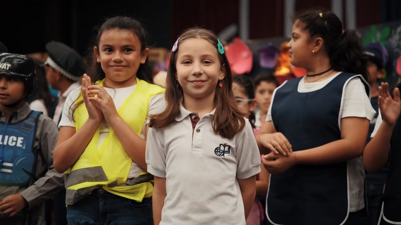 Alumna de primaria del CIG sonriendo con el uniforme del colegio, junto a sus compañeras en una actividad escolar.